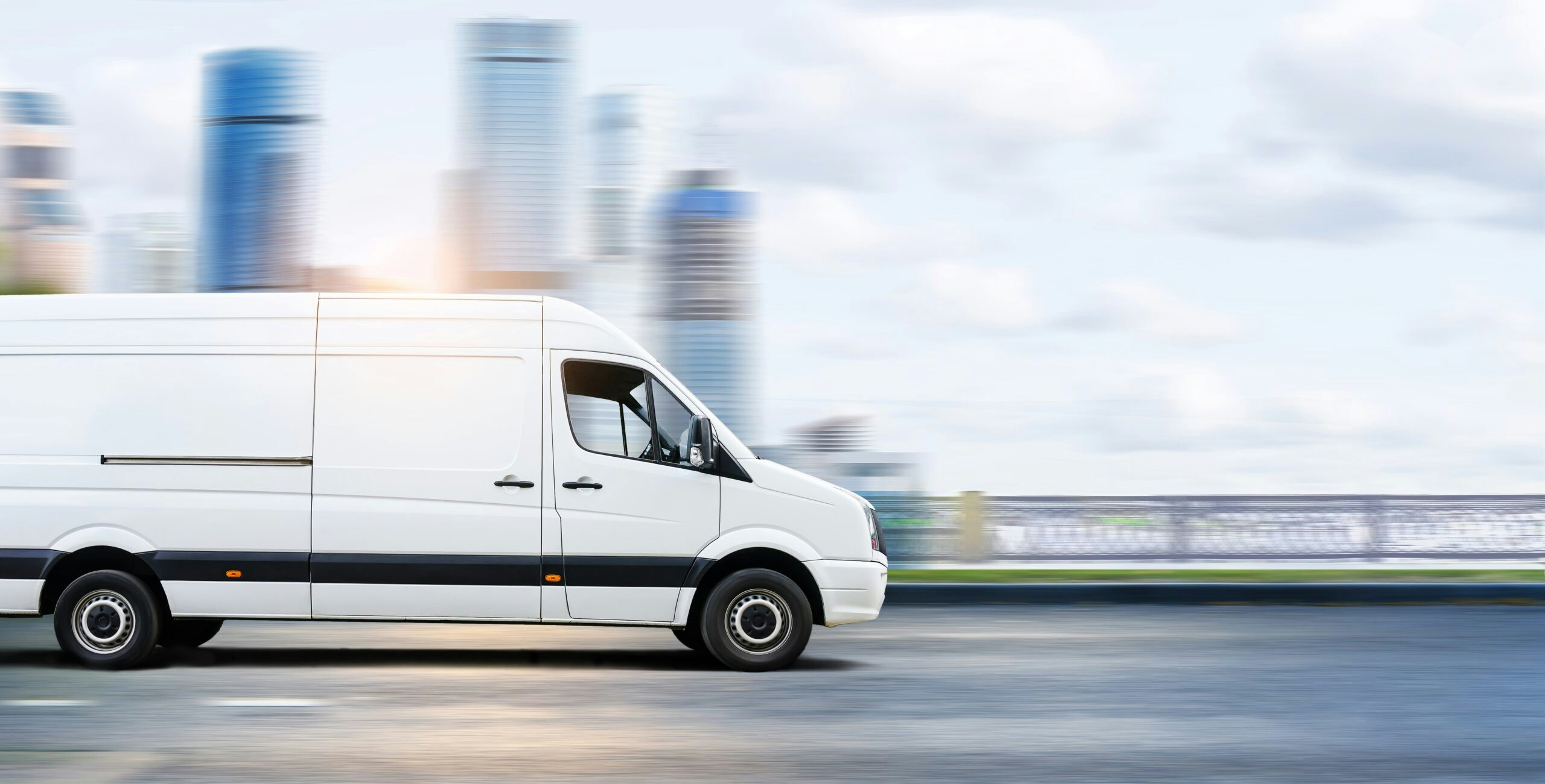 a van driving in front of a city