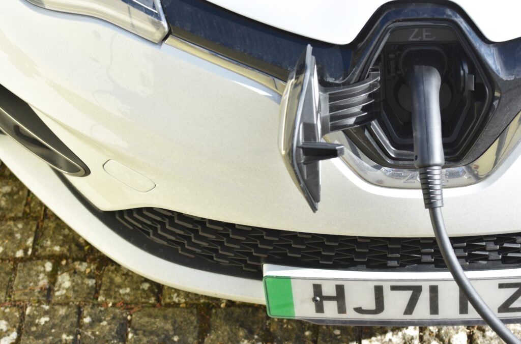 An EV charging with a green number plate