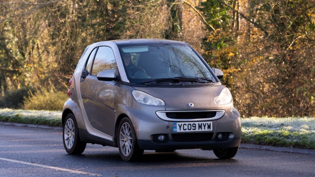 a woman driving a smart car