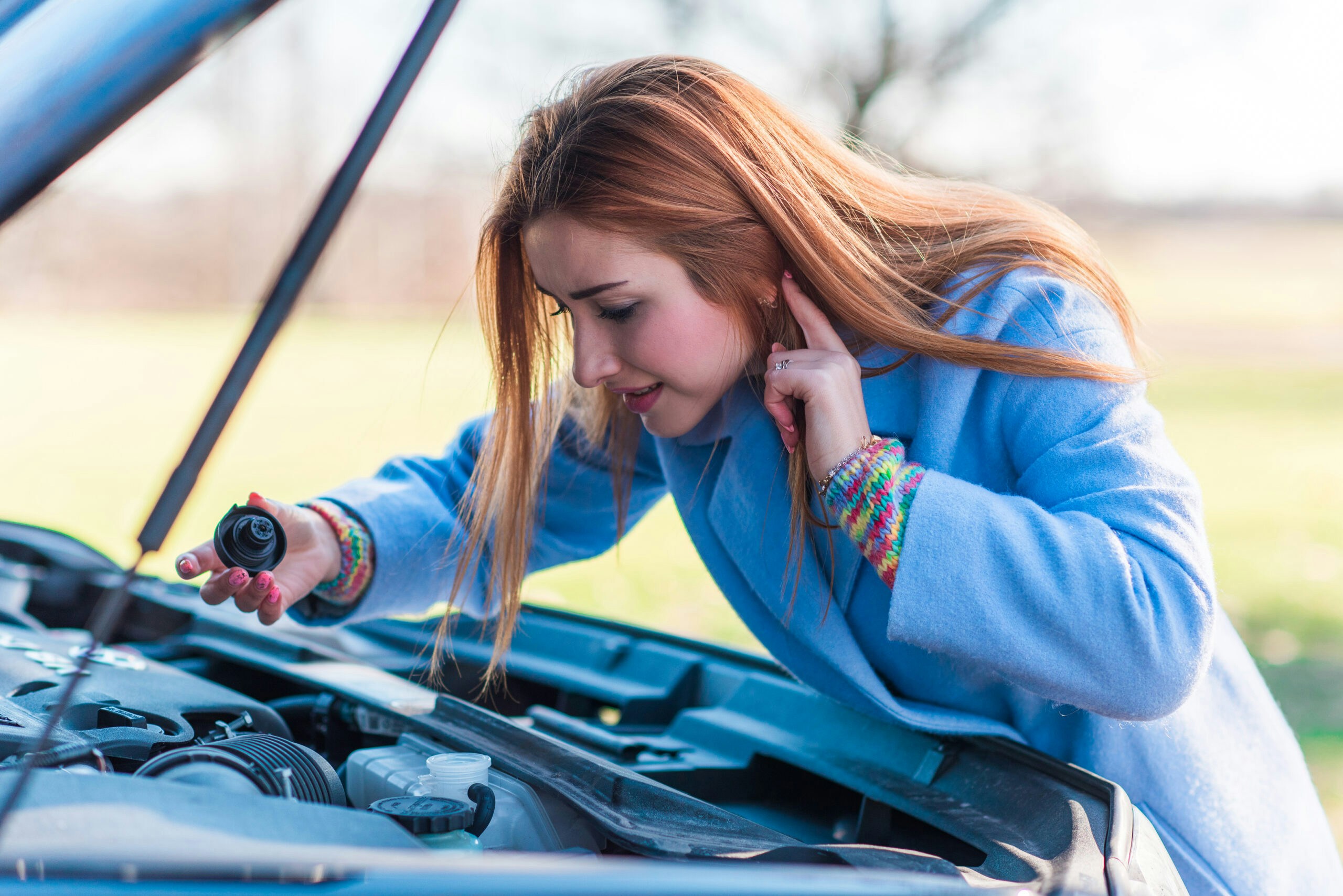 a woman checking the oil 