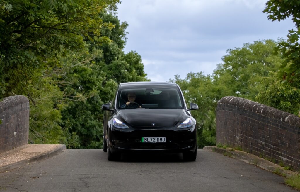 tesla driving over a bridge