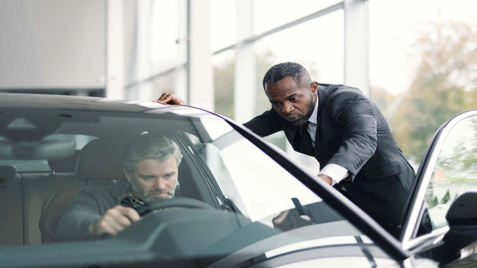 two men looking in a car